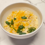 Loaded baked potato soup topped with shredded cheese and green onions