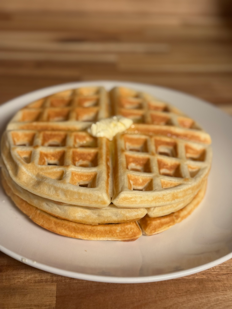 Fluffy homemade waffles from scratch with butter on top