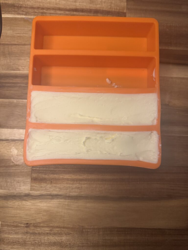 Homemade butter pressed into a silicone butter mold to form sticks after being made from heavy whipping cream.
