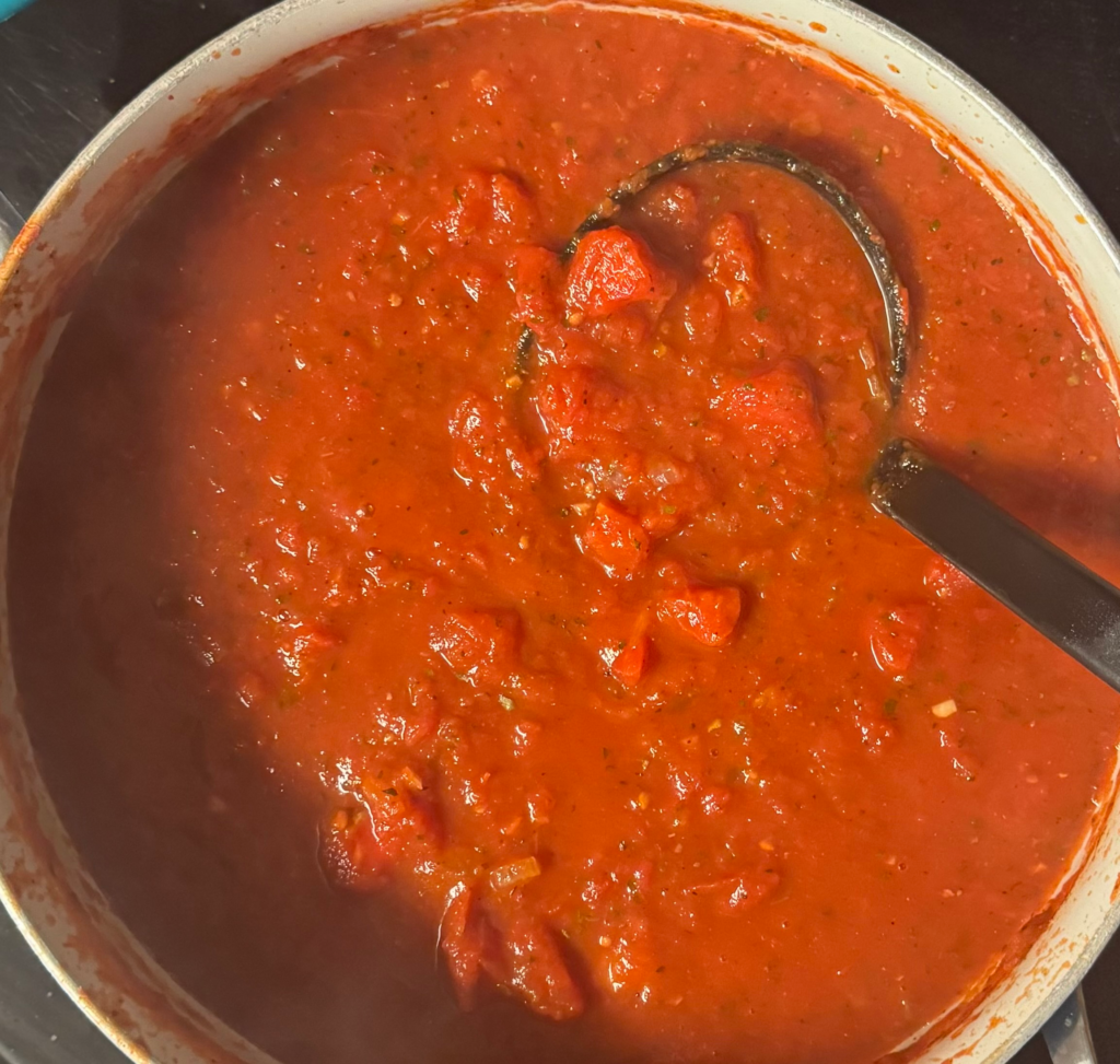 Chunky homemade spaghetti sauce simmering in a pot made with canned tomatoes and simple pantry ingredients