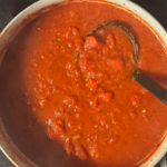 Chunky homemade spaghetti sauce simmering in a pot made with canned tomatoes and simple pantry ingredients
