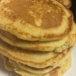 Southern hoe cakes stacked on a white plate, golden brown and crispy on the outside with a soft cornbread center.