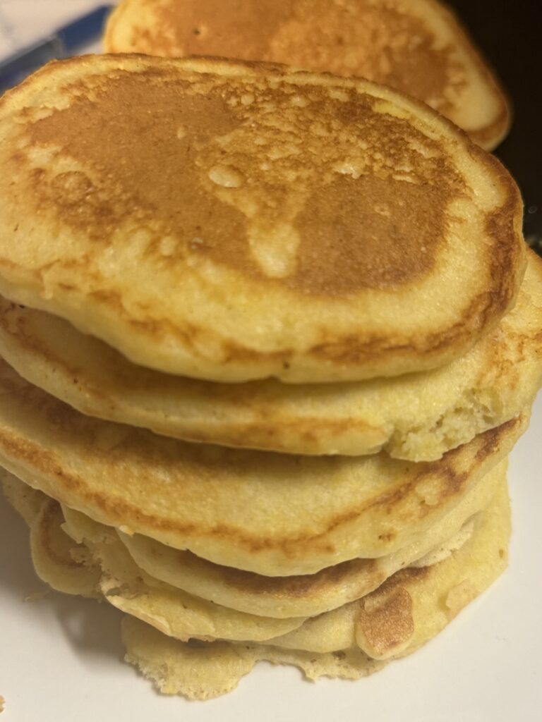 Southern hoe cakes stacked on a white plate, golden brown and crispy on the outside with a soft cornbread center.