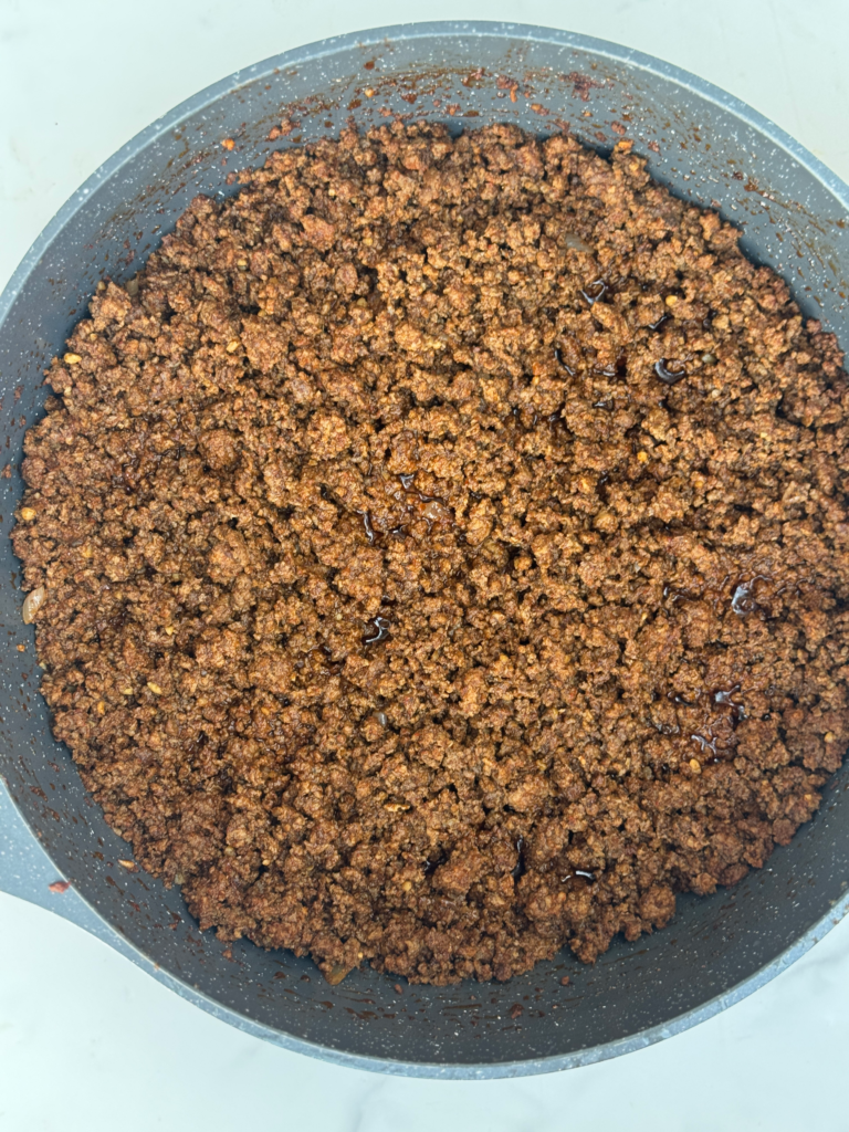 Seasoned ground beef cooking in a skillet for classic homemade ground beef tacos.