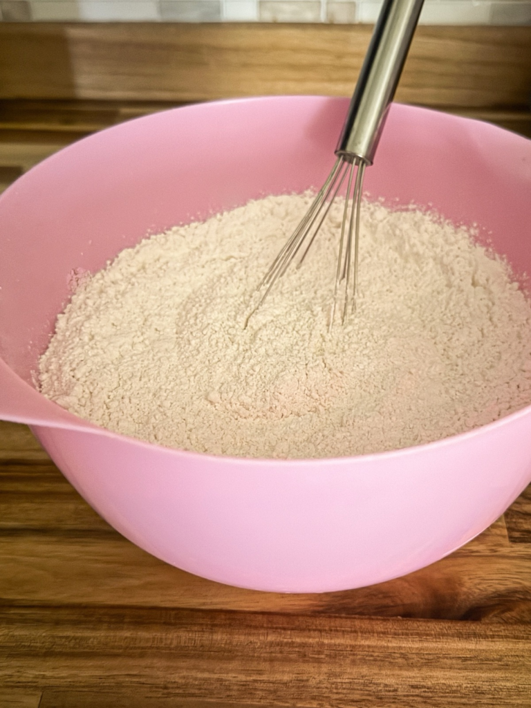 Whisking flour, baking powder, and salt together in a mixing bowl to make homemade Bisquick mix.