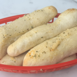 Soft Garlic Parmesan Breadsticks in a red bread basket.