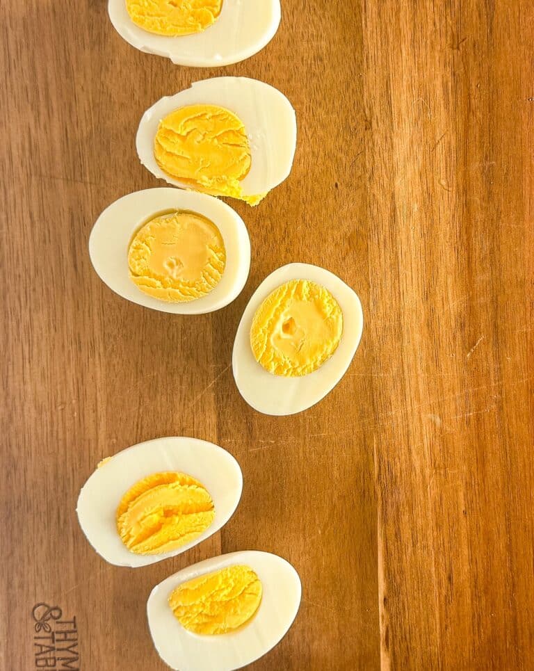 Perfect hard boiled eggs cut in half showing fully cooked yellow yolks and firm whites