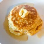 Easy homemade pancakes from scratch stacked on a plate with butter and syrup