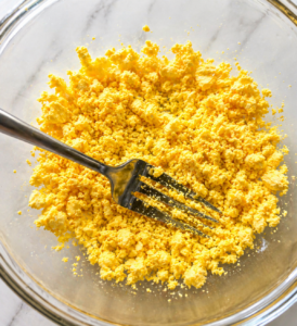 Mashed egg yolks in a bowl with a fork for deviled eggs recipe Mashed egg yolks in a bowl with a fork for deviled eggs recipe