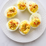 Classic Southern deviled eggs with relish and paprika on a white plate, creamy and homemade