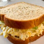 Egg salad sandwich made with creamy egg filling and lettuce on sliced white bread
